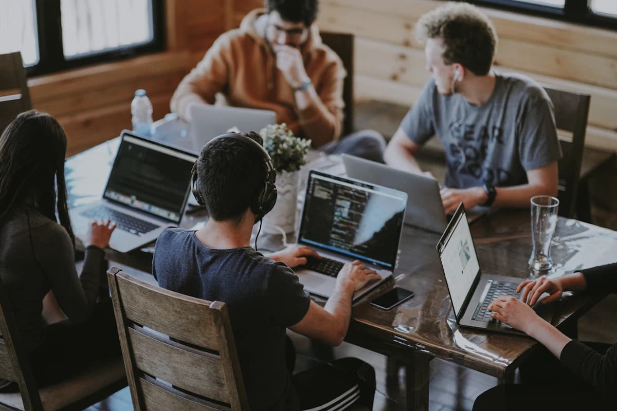 Tim profesional sedang mengerjakan website klien di workspace modern