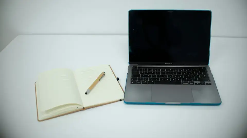 Laptop and notebook open to plan
