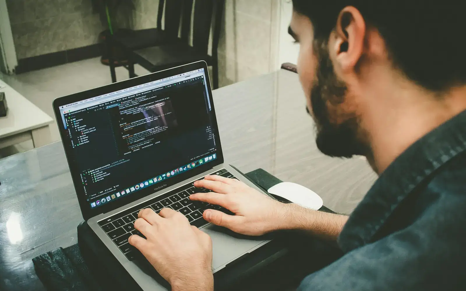 A developer typing application code on a laptop