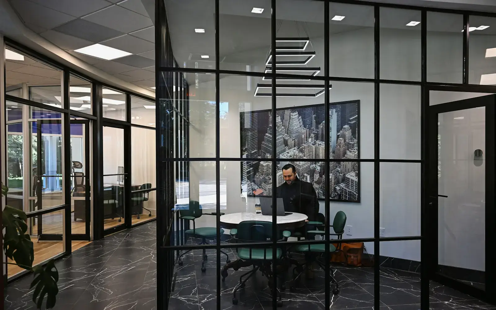 A person working on a laptop in an office meeting room