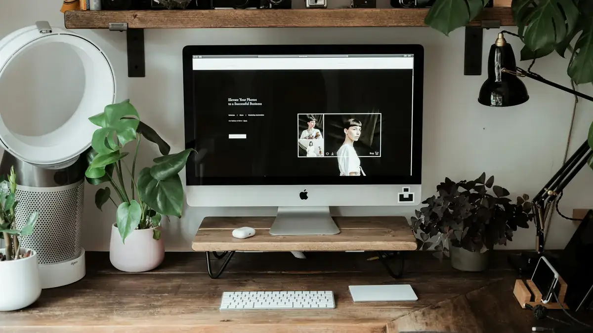 A website open on an iMac screen on a wooden desk