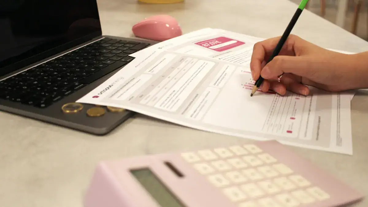 Dokumen biaya dan laptop di meja saat perencanaan anggaran