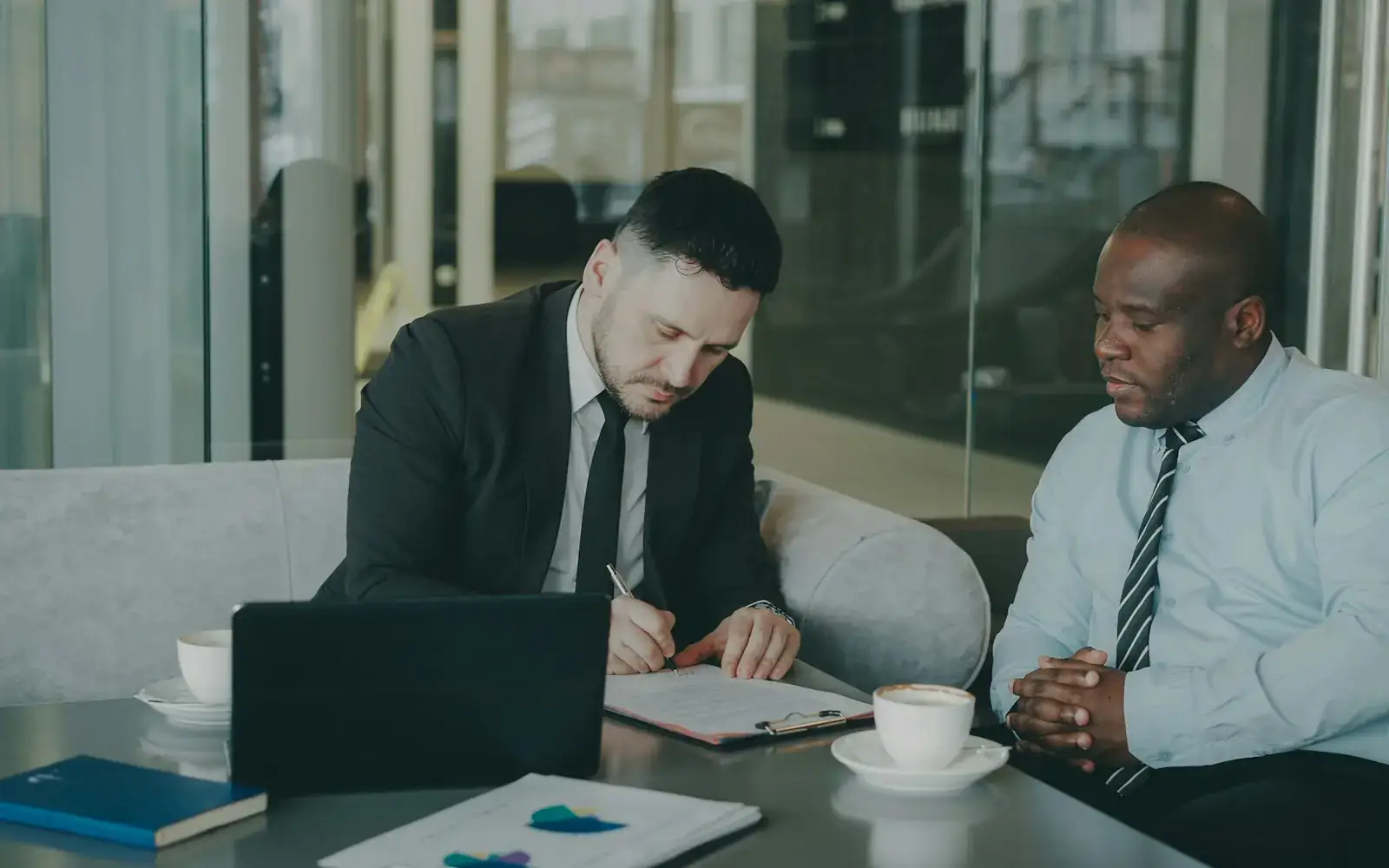 Two people reviewing and signing an agreement