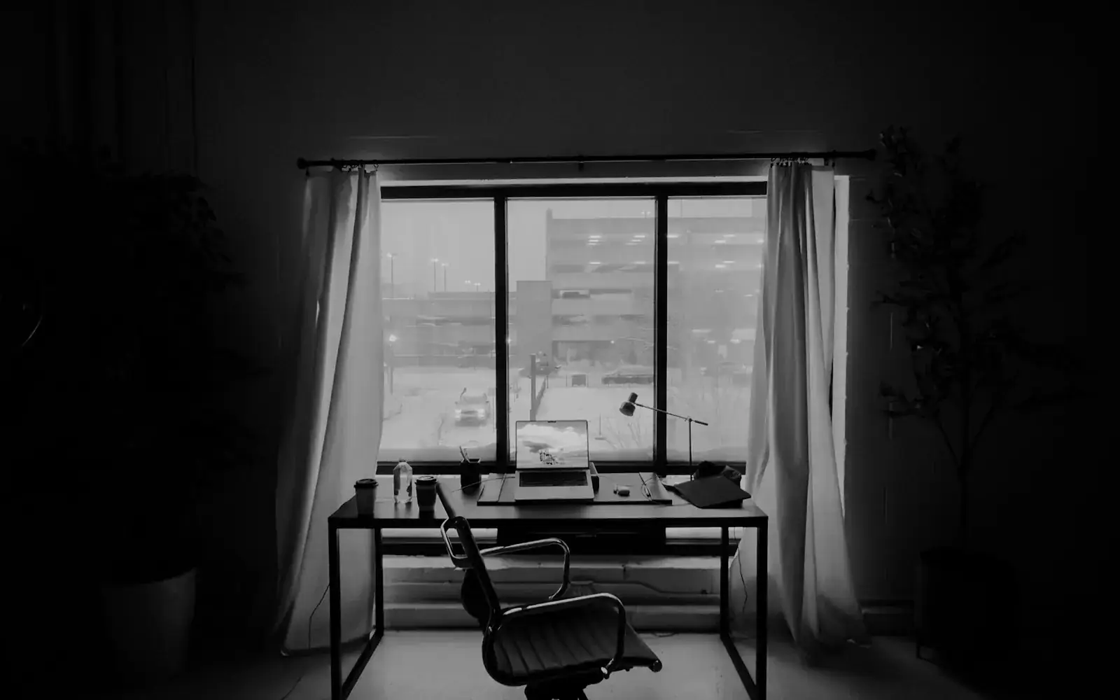 A desk and chair in front of a bright window